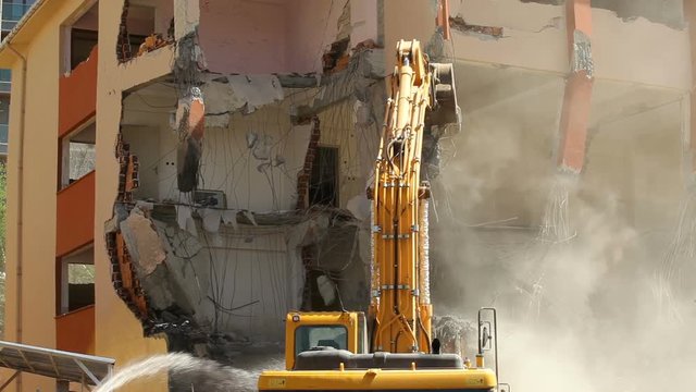 Video of excavator as a demolition machinery taking down a building