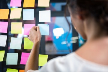 Businesswoman looking at sticky note