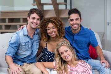 Happy young friends sitting on sofa