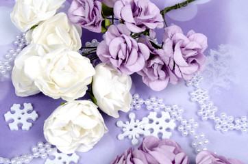 Paper flowers with snowflakes on lilac winter background
