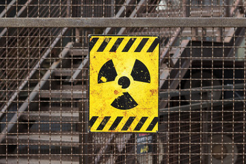 radioactive warning sign on rusty fence