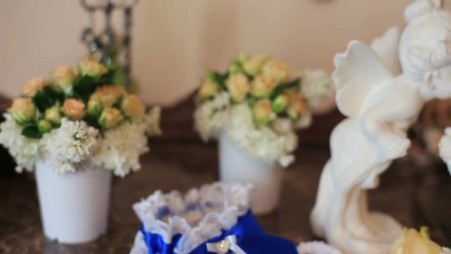 White ceramic sitting angels kissing on flowers background