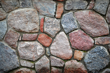 Wall made of natural stones of different colors and sizes