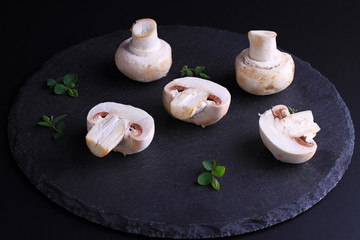 Fototapeta na wymiar Champignon mushrooms on black background. Cooking, Healthy eating concept.
