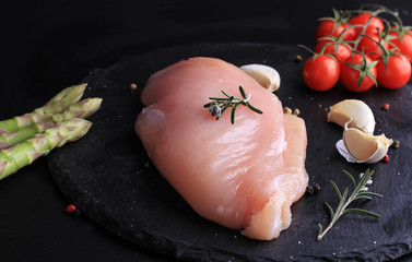 Raw chicken meat on black background. Cooking background