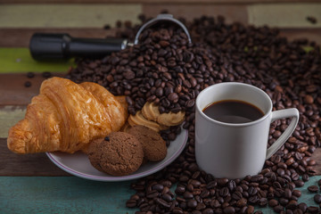 White coffee cup and cookies with beans background