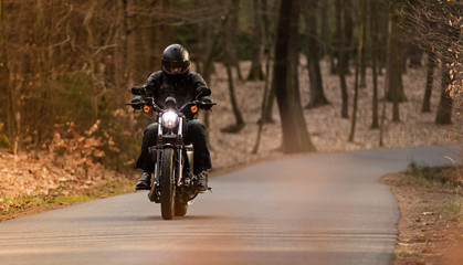 Man seat on the motorcycle on the forest road.