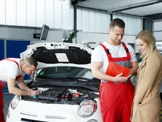 Customer and mechanic in a garage look at a quotation