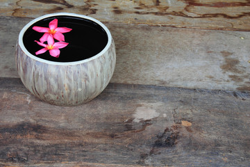 Image of spa  flowers in water on the old wooden desk.