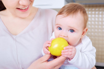 Fototapeta premium Bebe eats yellow apple.