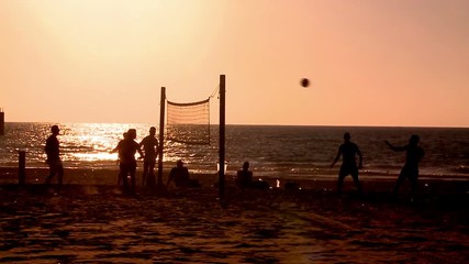 Sport. Foot volley.Young men and women playing brazilian foot volley , soccer on the sunset beach. Overhead kick, scissor kick. Silhouette. with sound 5