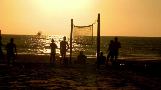 Sport. Foot volley.Young men and women playing brazilian foot volley , soccer on the sunset beach. Overhead kick, scissor kick. Silhouette. with sound 6