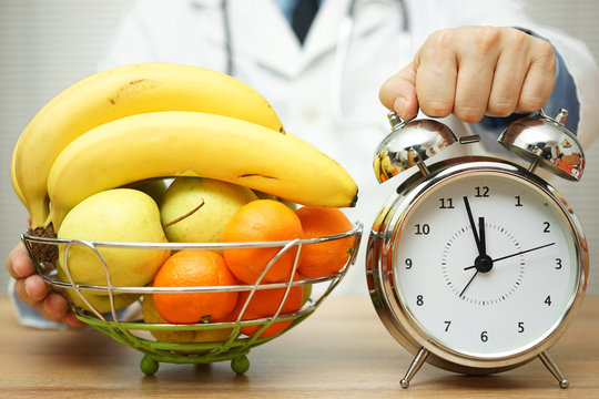 doctor is showing clock and fruit to patient to change eating ha