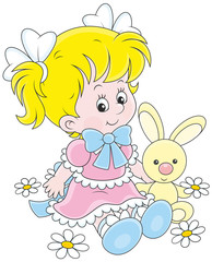 A cute little girl in a beautiful dress sitting with a small toy rabbit among flowers