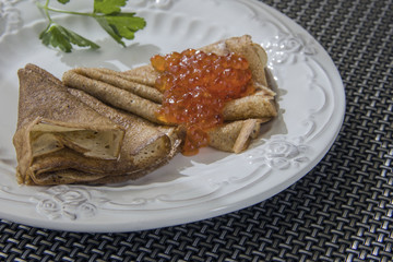 Pancakes with red caviar on a plate