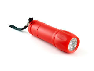 red plastic cylinder flashlight with led bulb and black strap isolated on white