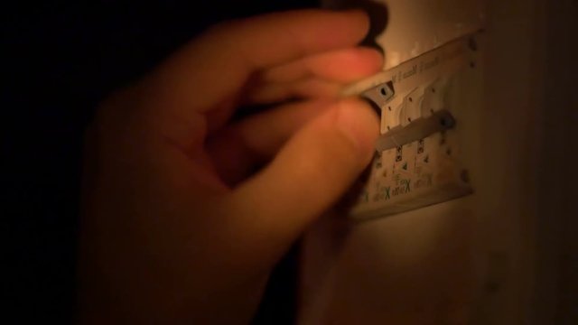Person is switching on the electric fuse after a power failure, from the electricity panel.