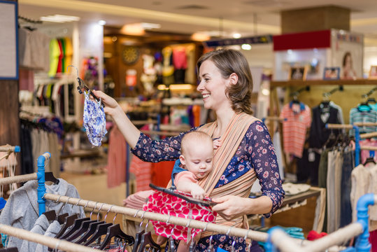 Young Woman With Baby In A Sling In Shopping Centre