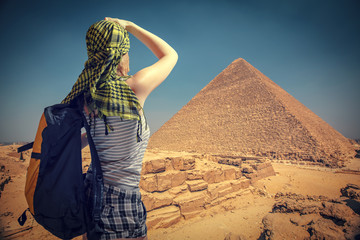 woman traveler with a backpack and the pyramids at Giza
