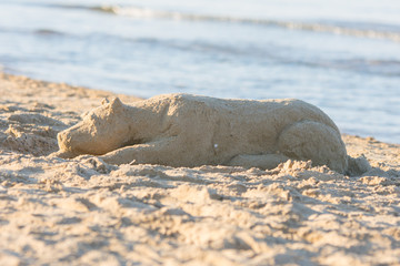 Sand figure sleplena dog on the beach