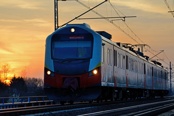 Train in the setting sun. - obrazy, fototapety, plakaty