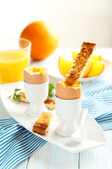 Boiled egg with toasts on a blue wooden table