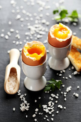 Boiled egg with toasts on a black wooden table
