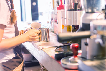 Barista mixing milk on espresso machine for making coffee, Latte