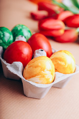 Sechs bunte Eierkerzen mit Tulpen
