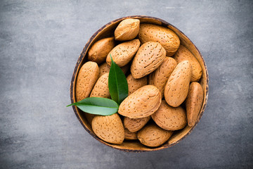 Group of almond nuts with leaves.Wooden background.