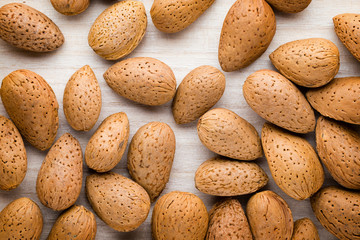 Group of almond nuts with leaves.Wooden background.