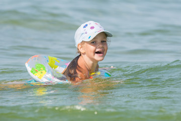 Joyful little girl swimming in a pond at the children's circle