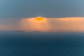 Fototapeta na wymiar Amazing sunrise above the sea through a cloudy sky. A magnificen