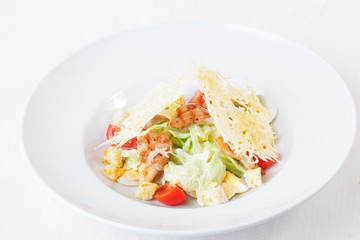 Caesar salad grilled chicken and parmesan crisps plate top white background isolated