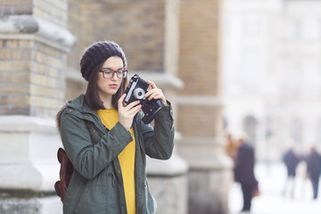 Young hipster woman takeing a pictures on vacation. She is carrying a backpack.