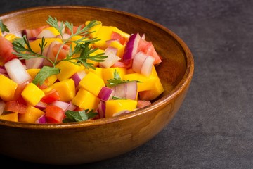 Homemade Mango salsa served in a wooden plate