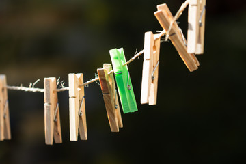 Clothes pegs on the clothesline.
One is colored green.