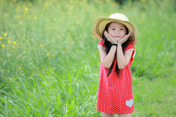 Portrait of beautiful happy little girl in a field of yellow flower