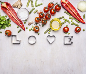 concept of good nutrition, various vegetables, spices and oil, with the word Love border ,place for text  on wooden rustic background top view