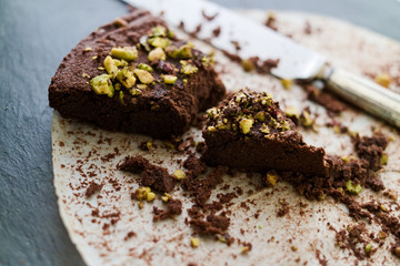 Crumbling last piece dark chocolate and pistachio cake