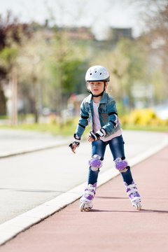Little caucasian girl on inline skates