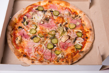 Close-up shot of tasty Italian pizza with ham, and onion