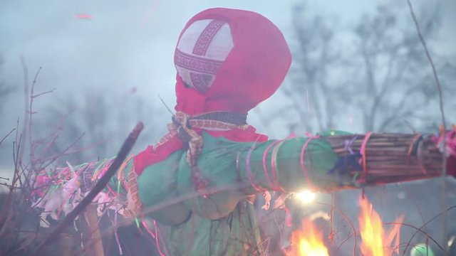 Burn doll on Shrove Tuesday. Russian holiday Maslenitsa. On the fire burned a doll
