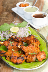 Delicious tandoori chicken starter, served with lime, onion, mint, yoghurt and sauces, on a banana leaf base.
