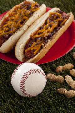 two hotdog sandwiches in plate with baseball ball and peanuts