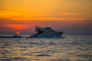 Luxurious boat sailing during sunset in Santorini, Greece.