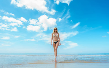 Vacation on the sea. Young sexy caucasian woman walk on ocean beach.