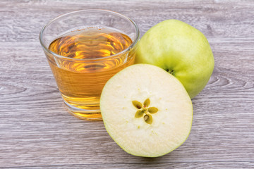 Apples and juice on a wooden background
