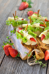 Käseröllchen mit Erdbeeren auf Ciabattabrot mit Salatblatt - Cheese rolls with strawberries on Italian ciabatta bread with lettuce leaves