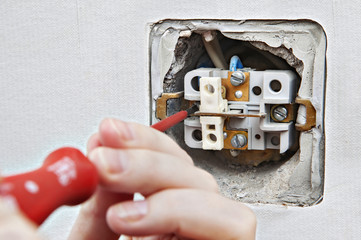 Change defective home electrical switch, dismantling of old device close-up.